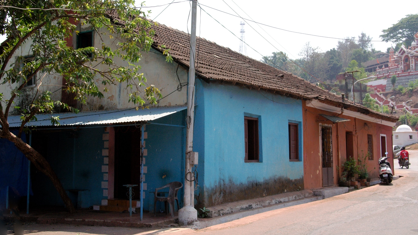 Rue déserte et maisons aux couleurs vives bleu et ocre-rouge en plein soleil de midi à Goa - Lors de mes voyages en Inde