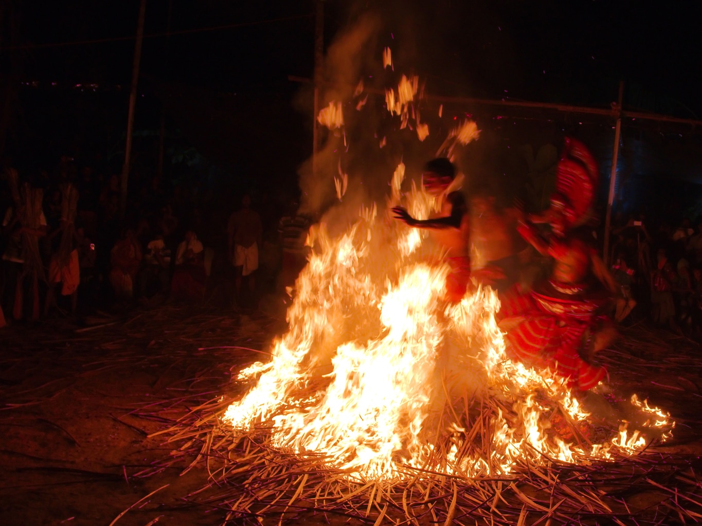 Kandanarkelan theyyam le performer et ses acolytes au milieu des flammes à Koodichira près de Payyanur