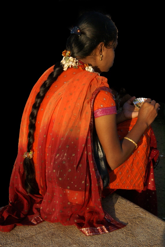 Une jeune femme à la tenue éblouissante mange un snack - bordure de mer - avenue Goubert Pondichéry