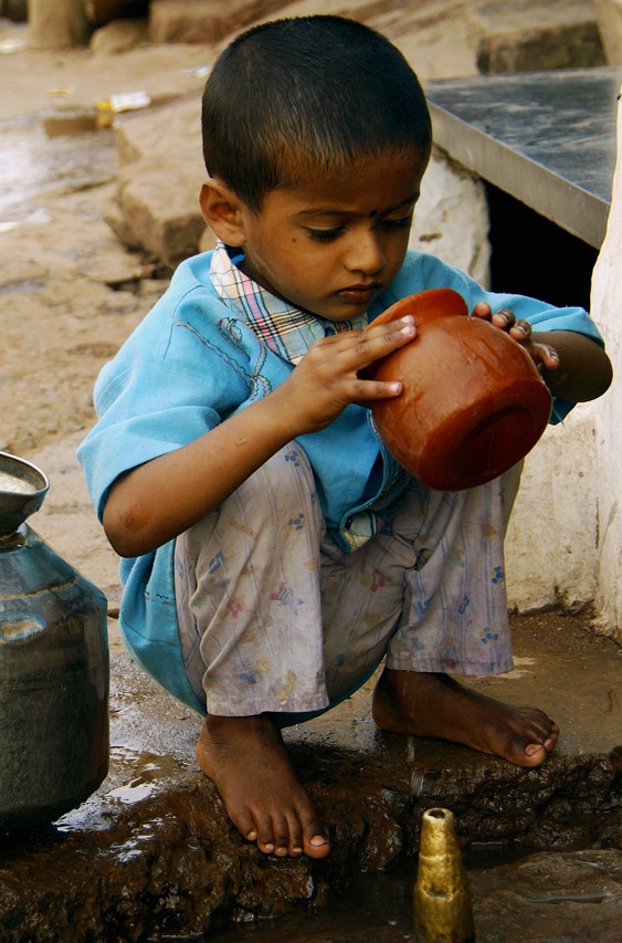 Un petit garçon très affairé à la fontaine - Badami