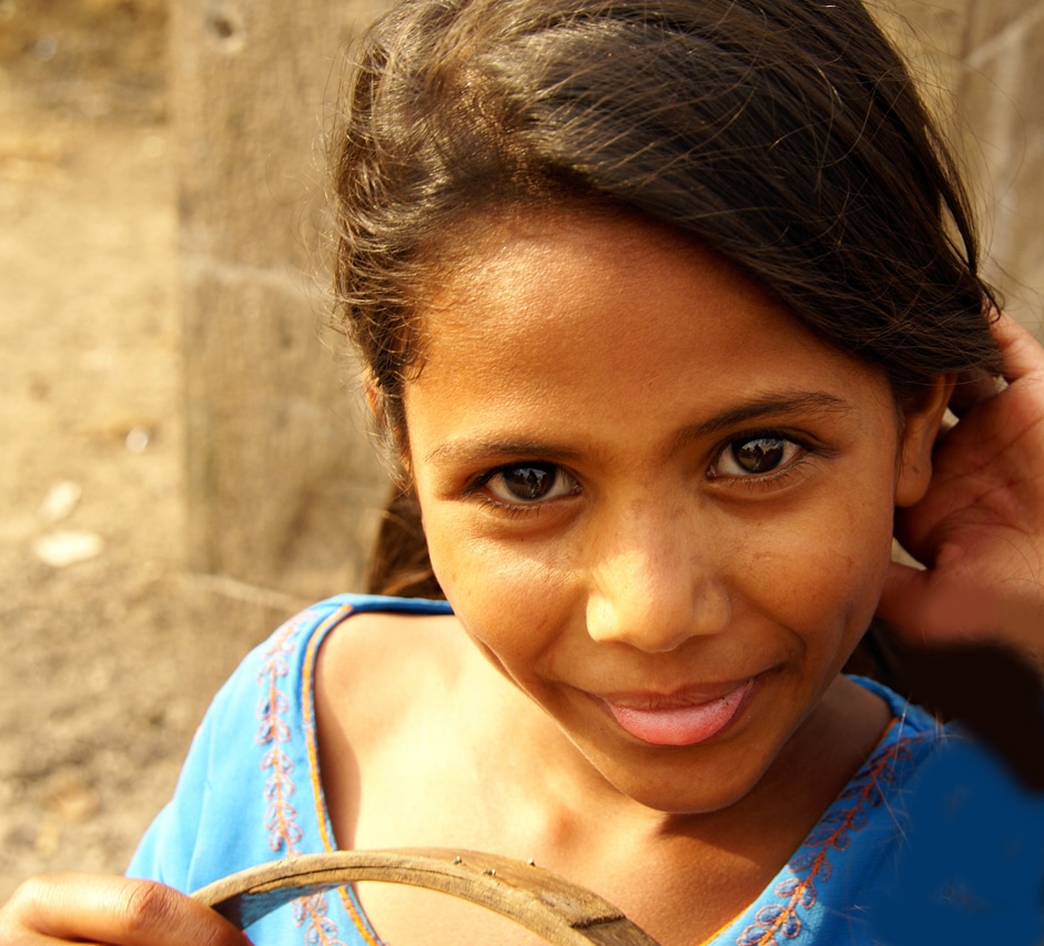 petite fille en robe bleue portant un panier - Bijapur