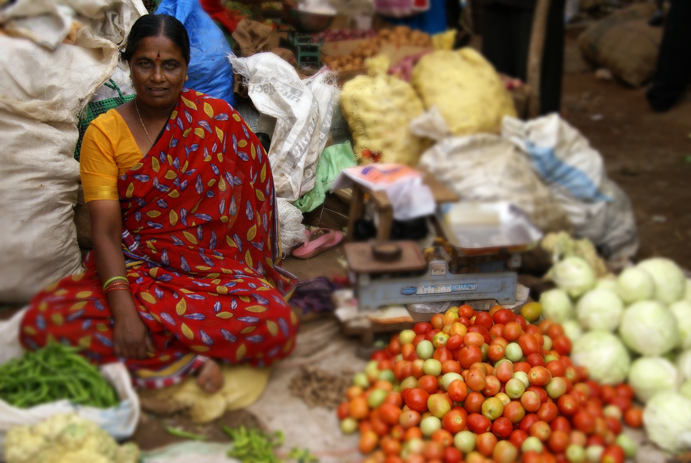 Le sari rouge et jaune de cette marchande est assorti à ses tomates sur le marché de Hassan