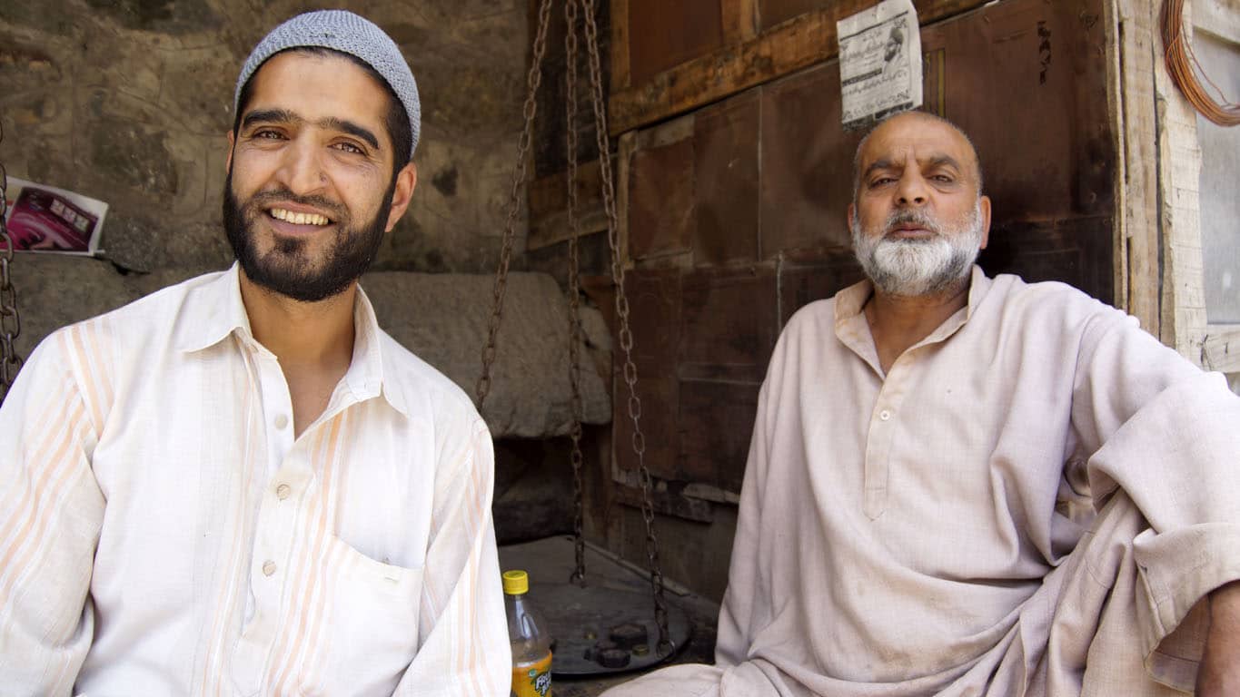 Deux boutiquiers souriants et heureux d'être photographiés dans le quartier de la vieille ville à Srinagar