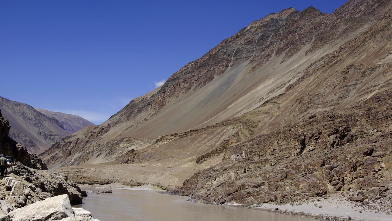 La rivière Zanskar en contrebas d'une montagne rocheuse en pente douce descendant jusqu'à elle en direction de Chilling