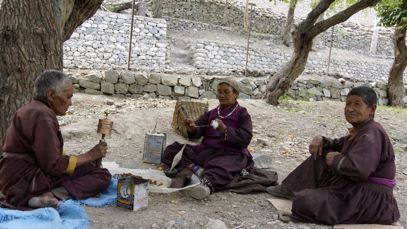 trois femmes papotent tout en filant la laine au fuseau à Tingmosgang Ladakh