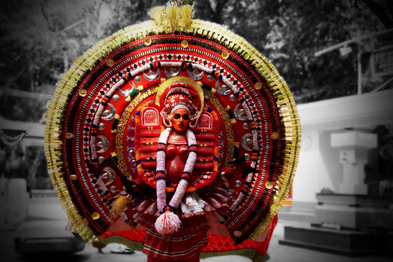 Costume theyyam en forme de roue rouge flamboyante sur fond de photo en noir et blanc Kannur Kerala Malabar