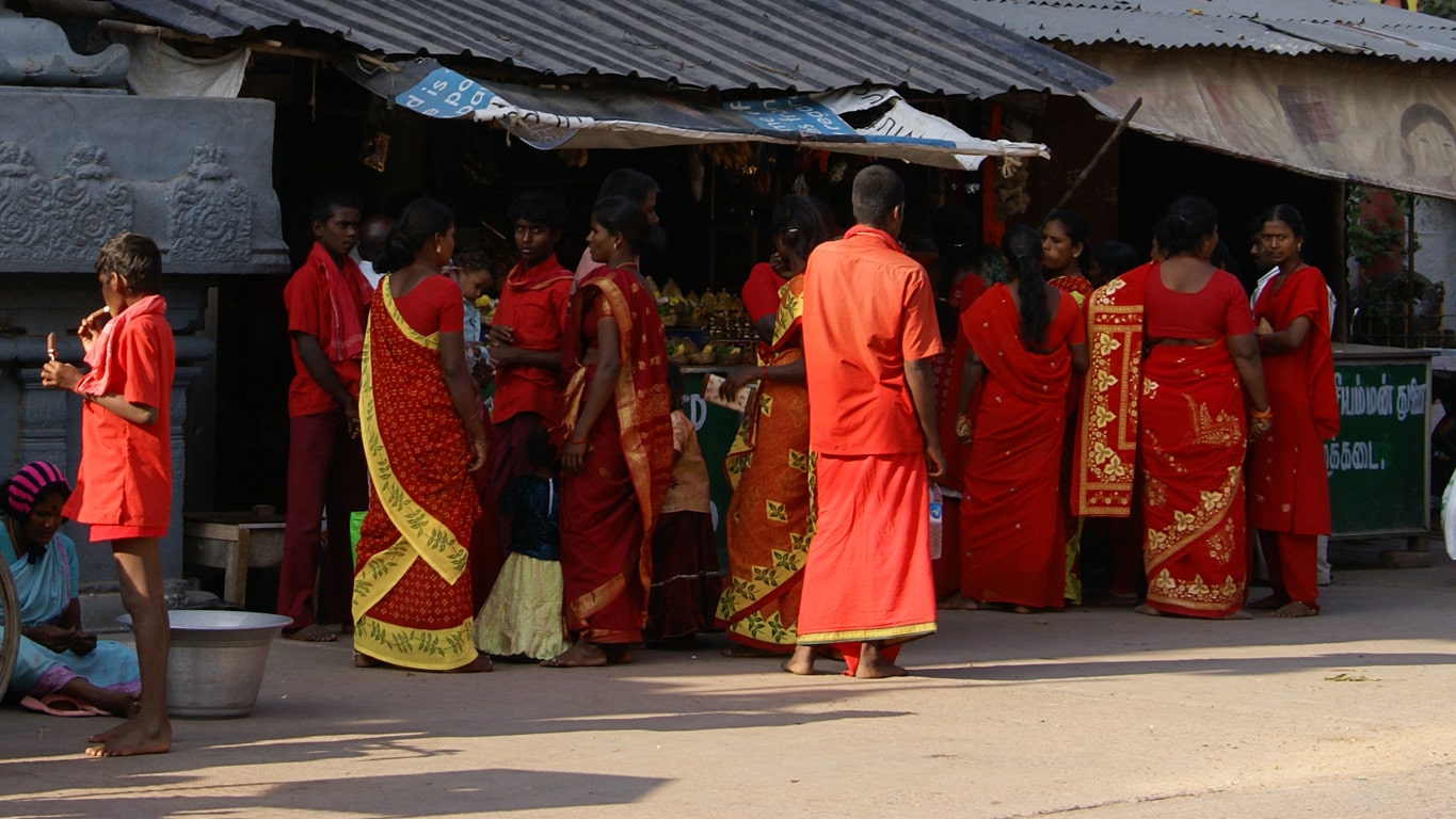 Pèlerins en rouge devant stand d'offrandes à l'entrée du Varadaraja temple Kanchipuram